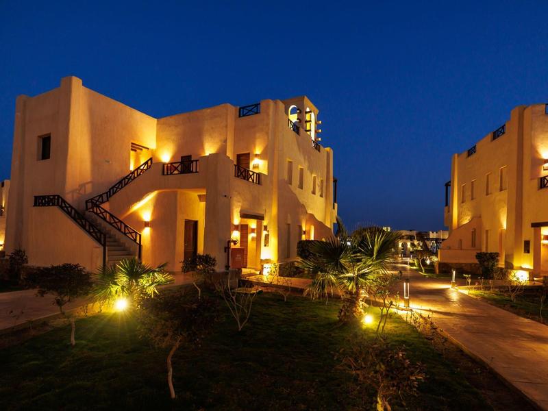 Edifici dell'hotel illuminati caldamente di notte con cielo blu scuro chiaro