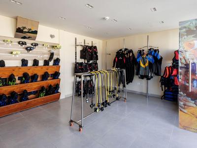 Indoor space with water sports gear including wetsuits and snorkeling equipment.