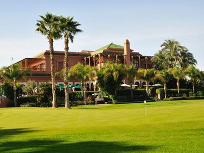 Luxuriöses Hotel mit Palmen und gepflegtem Golfplatz bei sonnigem Wetter