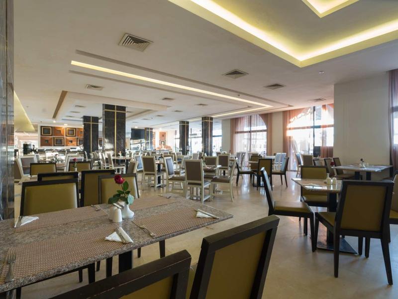 Salle à manger lumineuse et moderne avec tables et chaises dans un hôtel.
