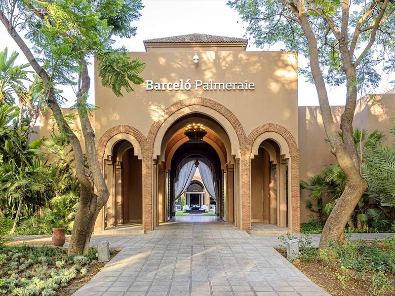 Vstup s oblouky a stromy vedoucí k hotelu Barceló Palmera.