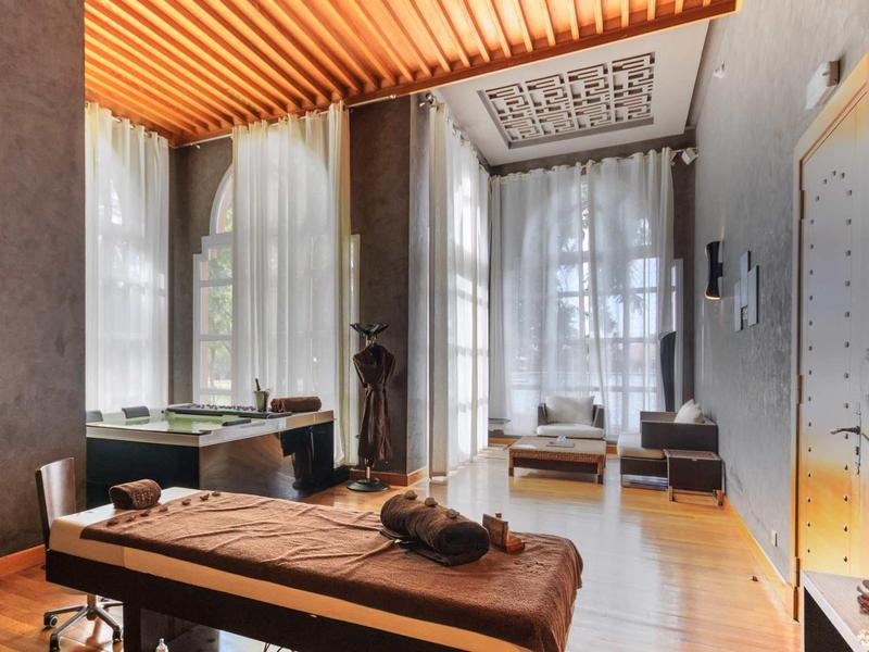 Pohodlná wellness místnost s masážními lehátky, jemným osvětlením a velkými okny.