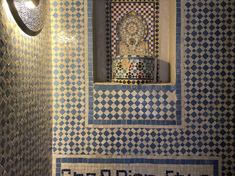 Parete a mosaico con scritta 'Spa & Bien-Être' e nicchia decorativa