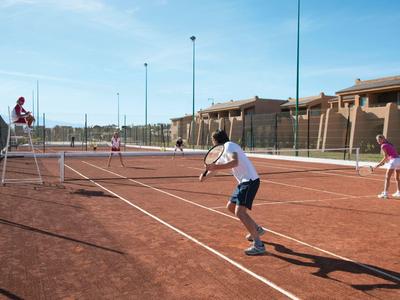 Menschen spielen Tennis auf einem roten Sandplatz mit einem Schiedsrichter auf einem Stuhl