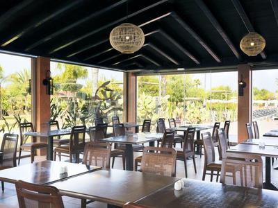 Open dining area with wooden furniture and a view of the garden.