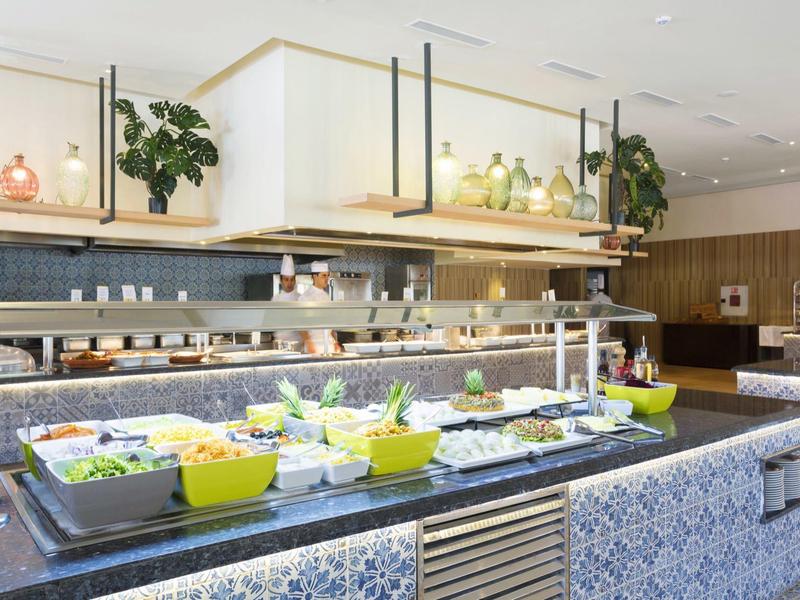 Buffet area with salads and fresh ingredients in a modern hotel restaurant.
