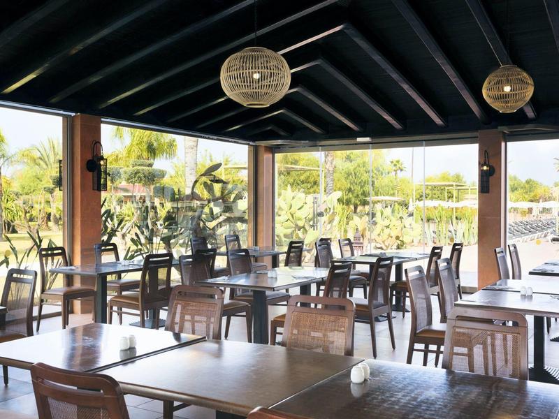Open dining area with wooden furniture and a view of the garden.