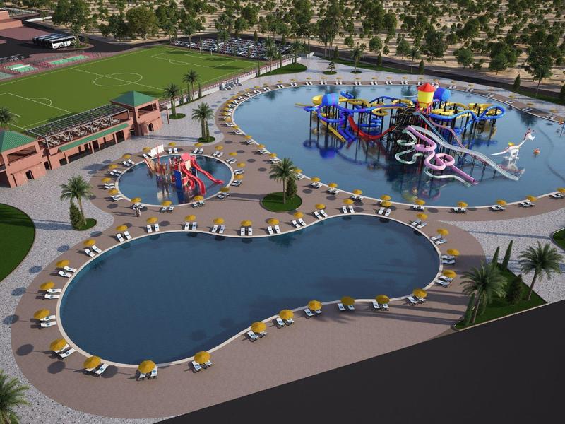 Grande parco acquatico con scivoli colorati, piscine multiple e sedie a sdraio.