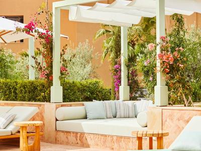 Gemütlicher Außenbereich mit gepolsterten Sitzgelegenheiten und Pflanzen in mediterranem Stil