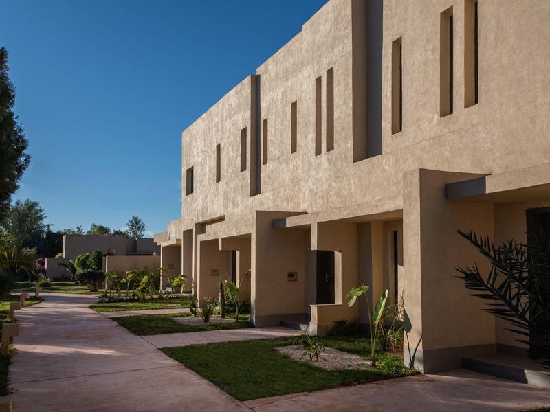 Maisons de vacances modernes à deux étages avec entrée et terrasse sous un ciel dégagé.