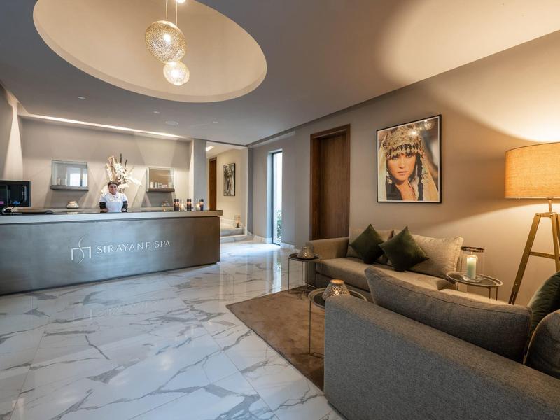 Hall d'hôtel moderne avec coin salon, réception et ambiance lumineuse chaleureuse.