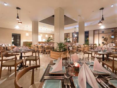 Elegantní moderní restaurace s teplým osvětlením a pečlivě prostřenými stoly.