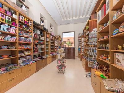 Interiér obchodu se suvenýry s regály plnými dárků a řemeslných výrobků.