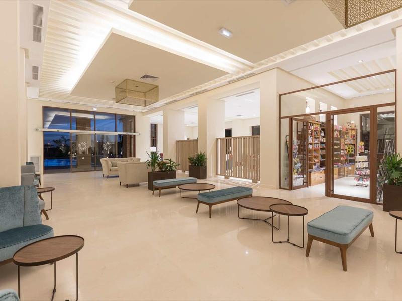 Espace lounge d'hôtel moderne avec sièges et grandes fenêtres.