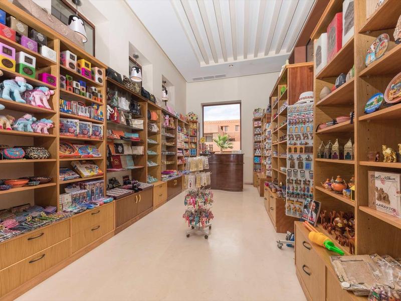 Vue d'une boutique de souvenirs bien organisée avec des étagères remplies d'articles colorés et une porte au fond.