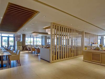 Bright modern restaurant with wooden elements and large windows for natural light.