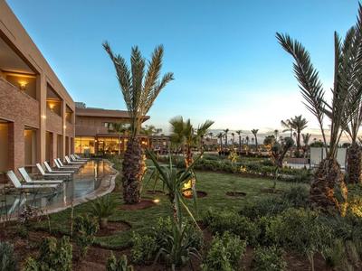 Nowoczesny ogród hotelowy z palmami i leżakami pod czystym niebem