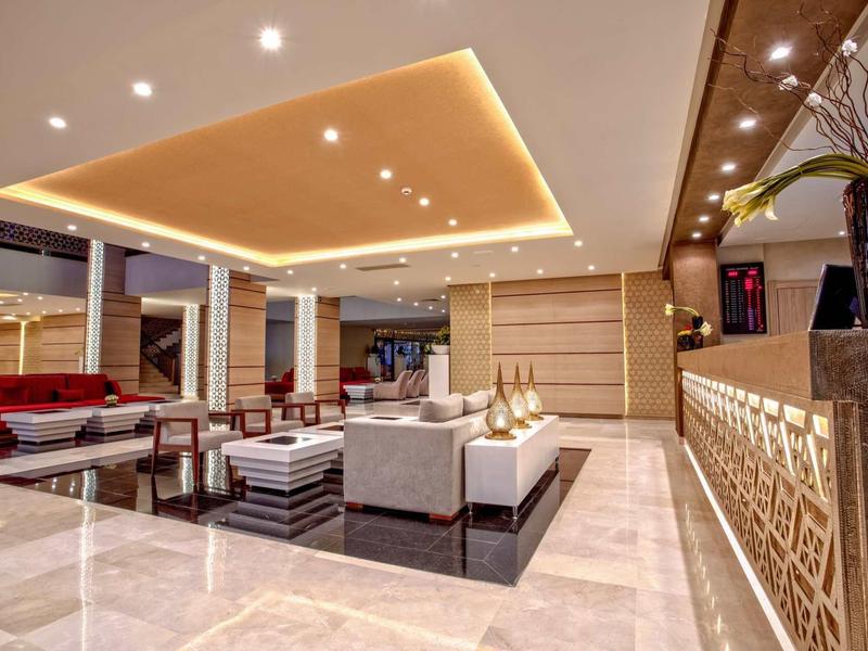 Nowoczesna lobby hotelowa z wygodnymi fotelami, sofami i stylowym oświetleniem.