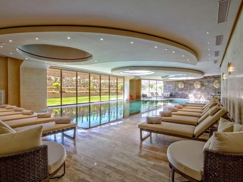 Elegancka przestrzeń basenowa wewnątrz z naturalnym światłem przez duże okna i wygodnymi leżakami.