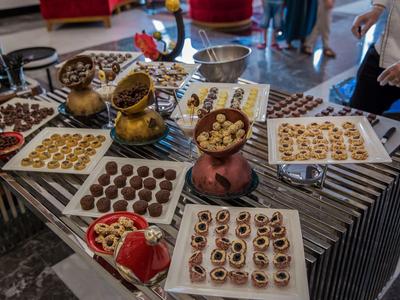 Una presentazione di cioccolatini e dolci assortiti su un tavolo in un hotel o caffè.
