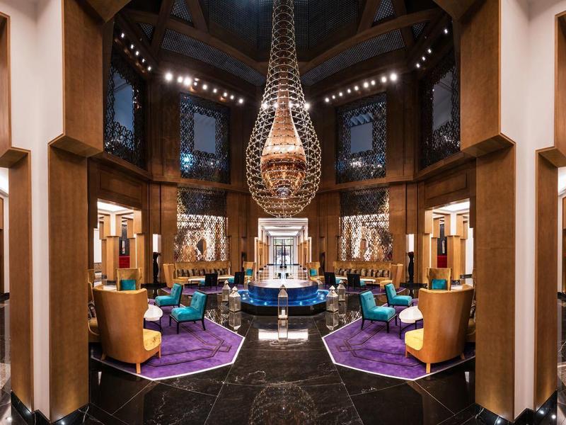 Interno di un hotel di lusso con eleganti aree salotto e atmosfera calda.