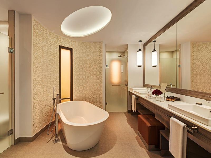 Bagno moderno dell'hotel con vasca da bagno freestanding e grandi specchi.