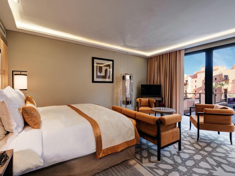 Camera d'hotel moderna con letto grande, area salotto e vista sulla città.