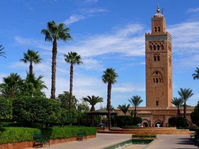 Koutoubia-Moschee mit palmenbewachsenem Garten bei klarem Himmel in Marrakesch.