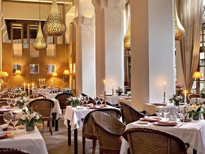 Elegant restaurant met witte tafelkleden en warme verlichting in een hotel.