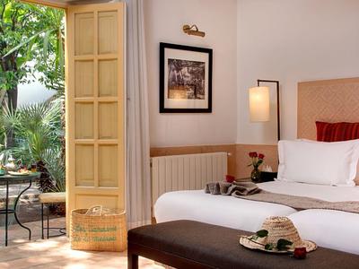 Modern hotelkamer met open toegang tot een terras en uitzicht op de tuin.