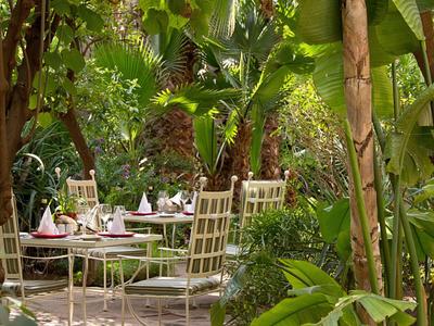 Buitengebied omgeven door weelderig tropisch groen met gedekte tafels.