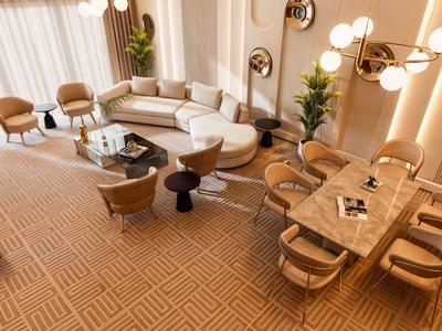 Modern eingerichtetes Hotelzimmer mit gemütlicher Sofaecke und elegantem Esstisch.