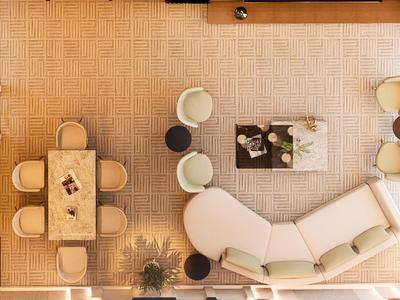 Hell eingerichtetes Wohnzimmer mit großem, weißem Sofa und Holztisch neben Essbereich.