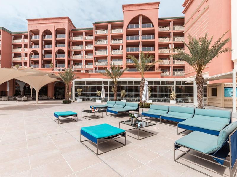 Modern hotel met meerdere verdiepingen en comfortabele zitruimte buiten.