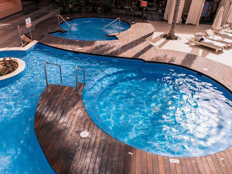 Luxe hotelzwembad met rond zwembad en houten dek