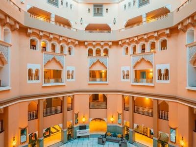 Innenhof eines luxuriösen Hotels mit warmen Pastellfarben und eleganter Architektur.