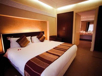 Modern eingerichtetes Hotelzimmer mit großem Doppelbett und warme Beleuchtung.