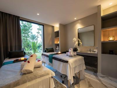 Sala spa moderna con due lettini da massaggio e finestra panoramica in un hotel.