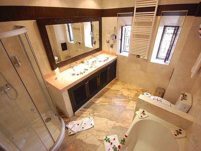 Modern bathroom with shower, bathtub, double sink, and window lighting.