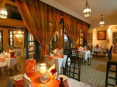 Elegant hotel restaurant with white tablecloths and warm lighting.