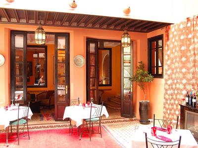 Cozy courtyard with tables, chairs, and warm lighting, perfect for hotel guests.