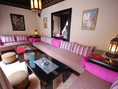 Cozy seating area with pink striped cushions, lanterns, and decorations in a hotel room.