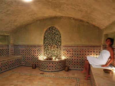 Interiér hammamu s vzorovanými zdmi a mozaikovou nikou.