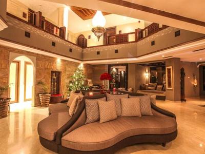 Geräumige Hotellobby mit geschwungenem Sofa, warmen Beleuchtungselementen und dekorativen Details.