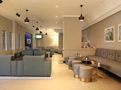 Nowoczesny hotelowy salon z wygodnymi miejscami do siedzenia, sofami i stonowanym oświetleniem.