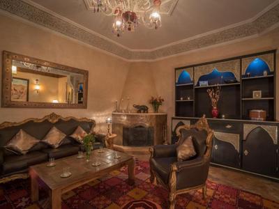 Elegantes Wohnzimmer mit Ledermöbeln, Kamin und großen Spiegeln in warmen Farbtönen.