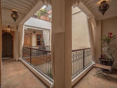 Innenhof eines Hotels mit geschwungenem Balkon und dekorativen Laternen.