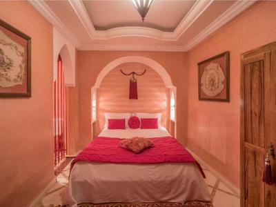 Gemütliches Schlafzimmer mit warmen Farben und orientalischer Dekoration in einem Hotelzimmer.