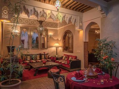 Gemütlicher, orientalischer Innenraum mit roten Polstern, Ornamenten und Pflanzen in einem Hotel.