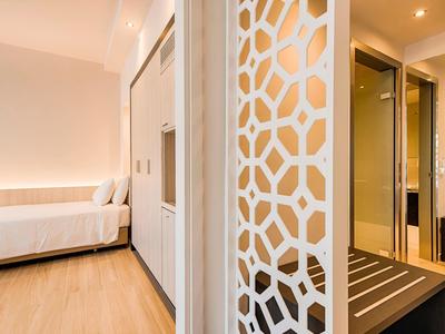 Moderner Hotelflur mit Holzfußboden, dekorativer Wand und Blick auf ein helles Gästezimmer.